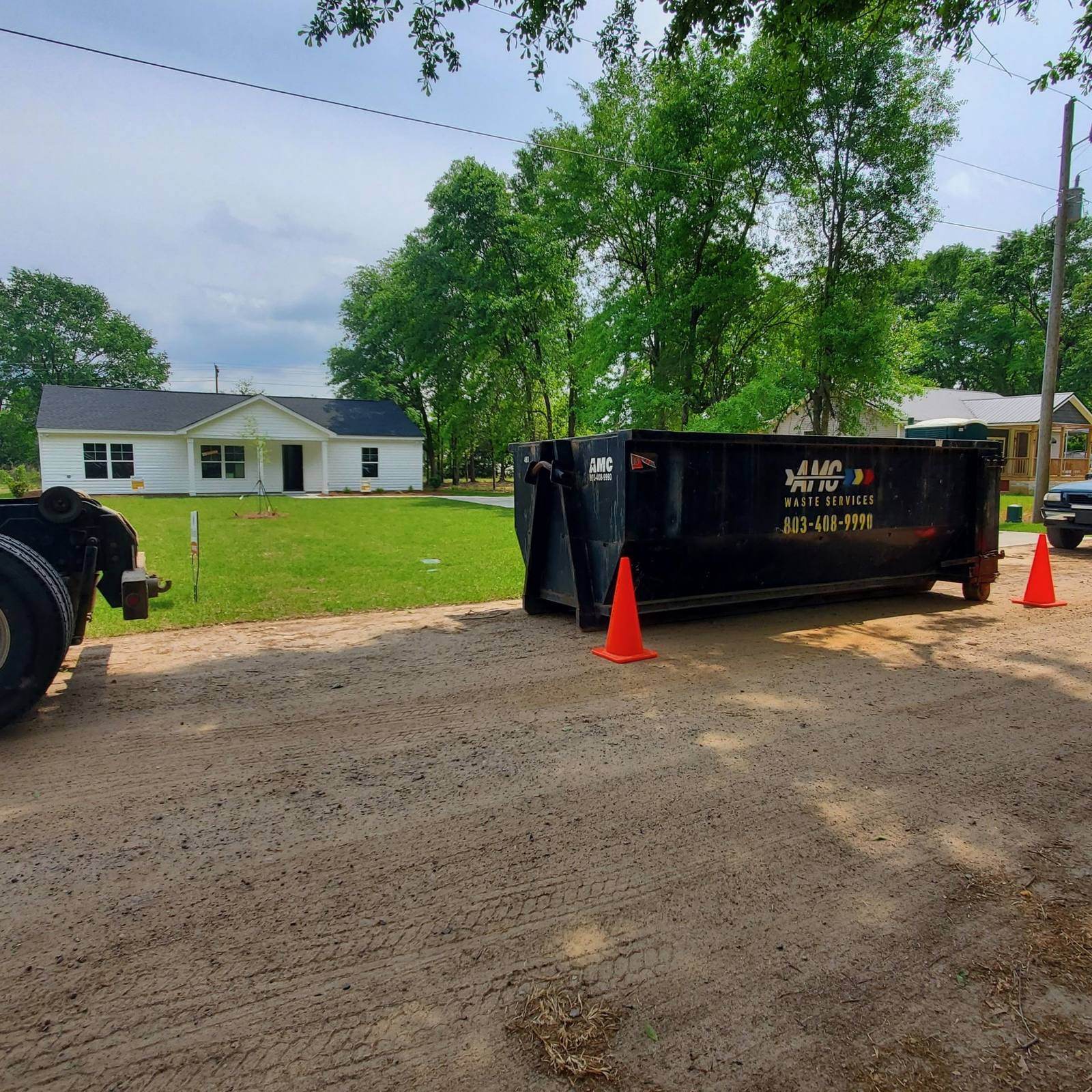 An AMC Waste Services dumpster set in a driveway in Camden, Kershaw County, SC