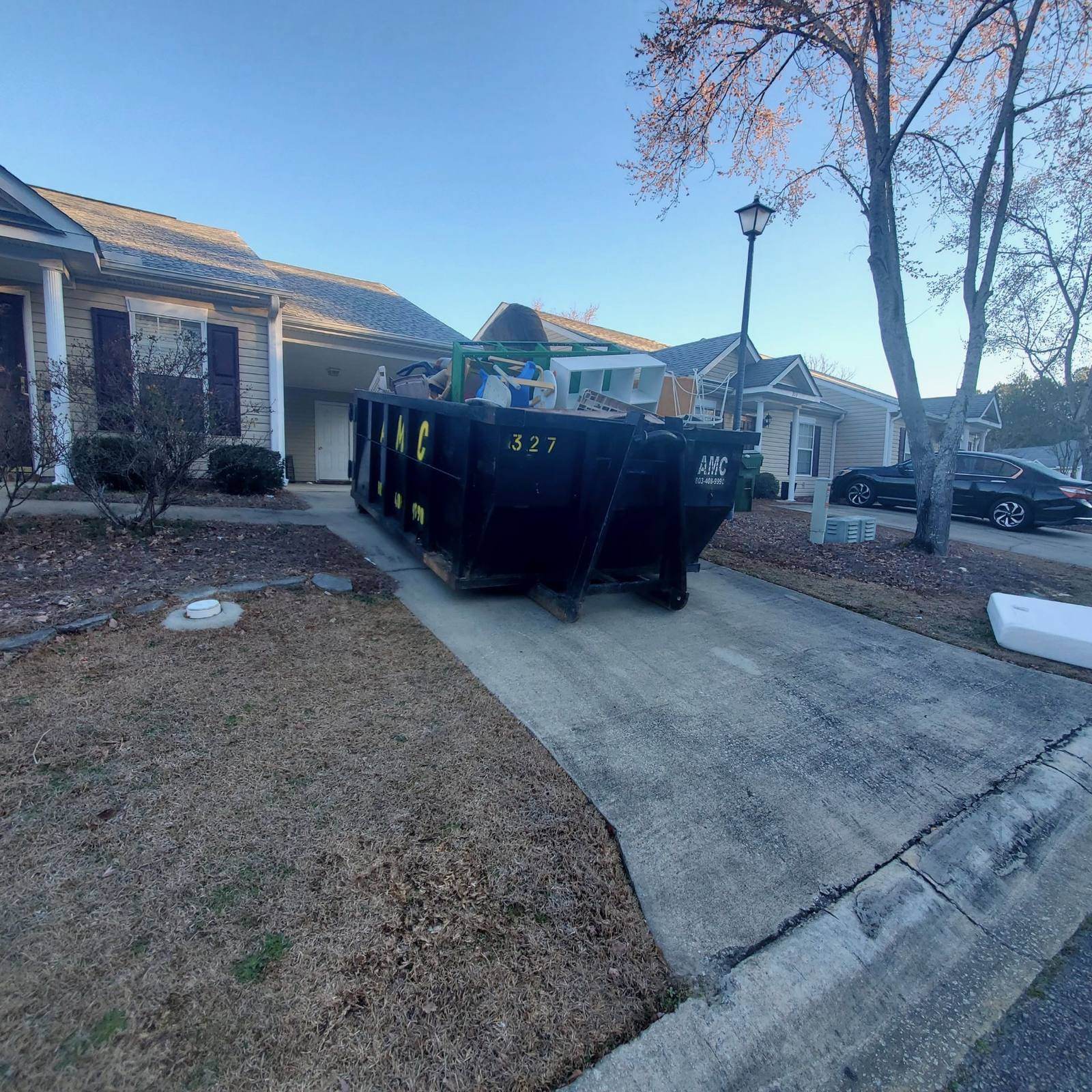 An AMC Waste Services dumpster dropped at the curb of a home in Aiken, Aiken County, SC