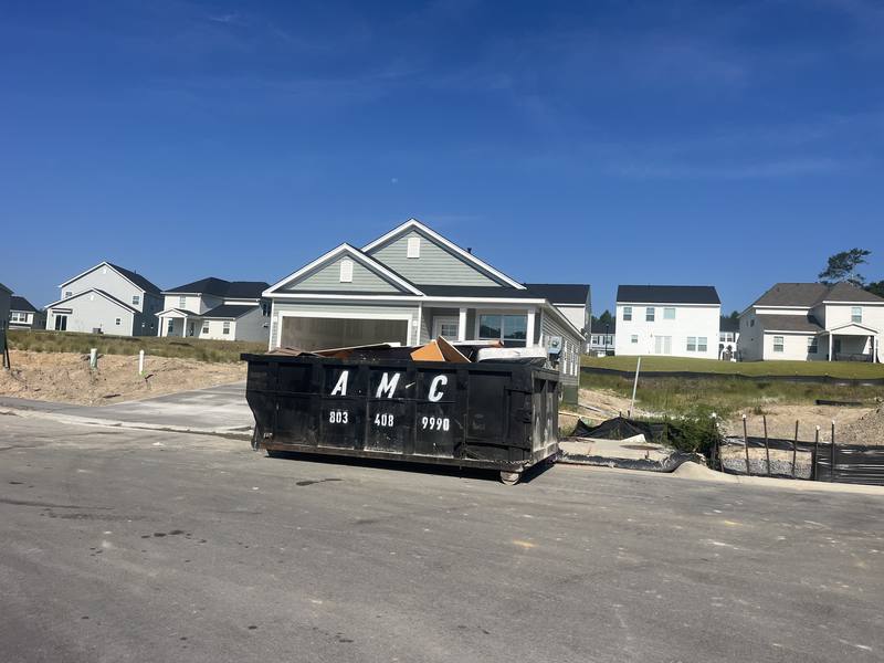 An AMC Waste Services roll-off dumpster set in a new subdivision in Lexington, Lexington County, SC