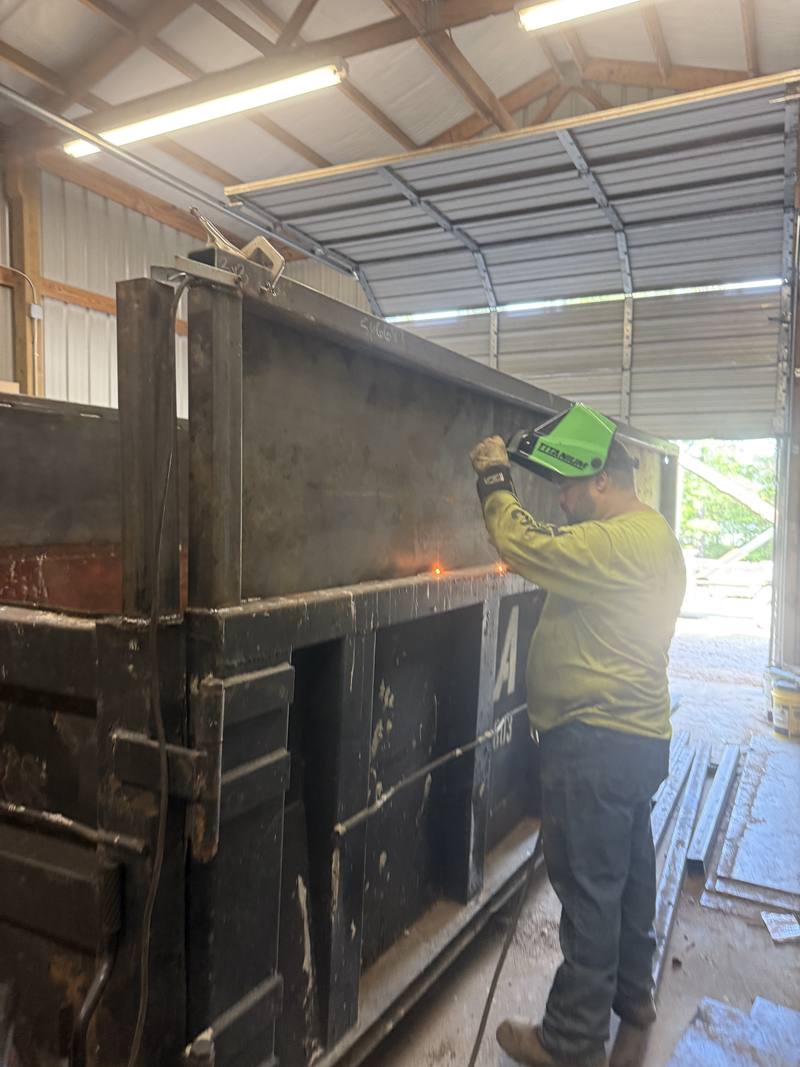 Welding a roll-off dumpster in the AMC Waste Services shop