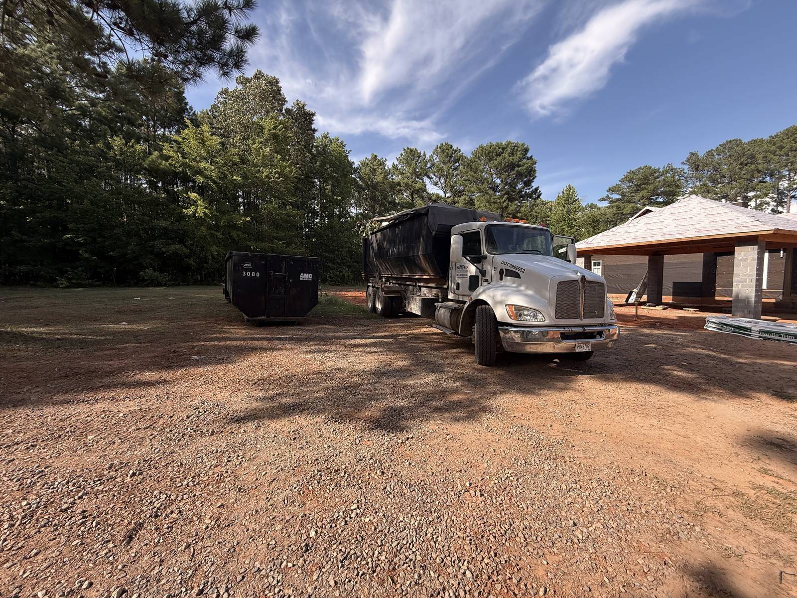 An AMC Waste Services truck delivering a dumpster on a new build in Blythewood, Richland County, SC
