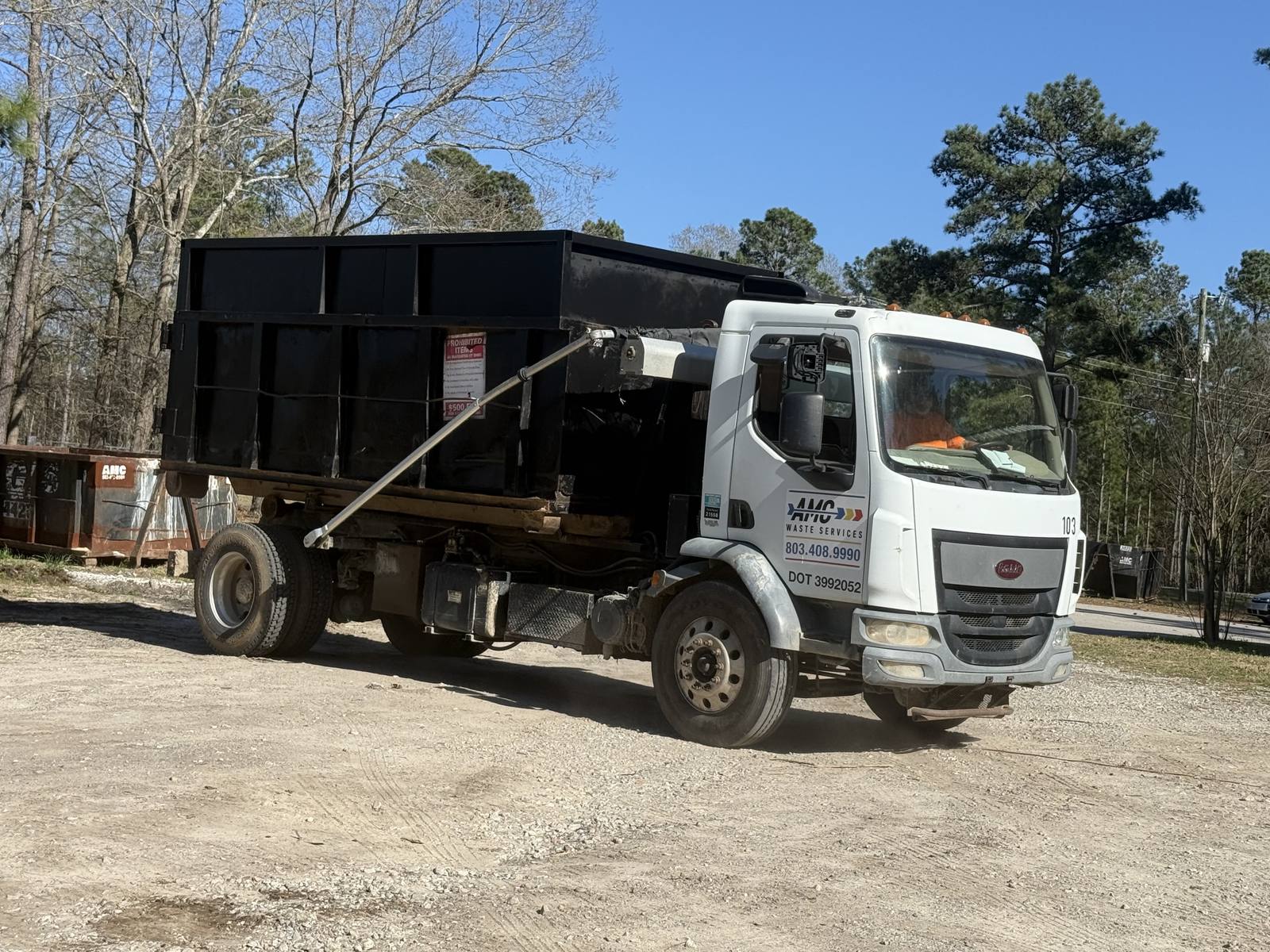 An AMC Waste Services truck hauling a loaded dumpster in Florence, Florence County, SC